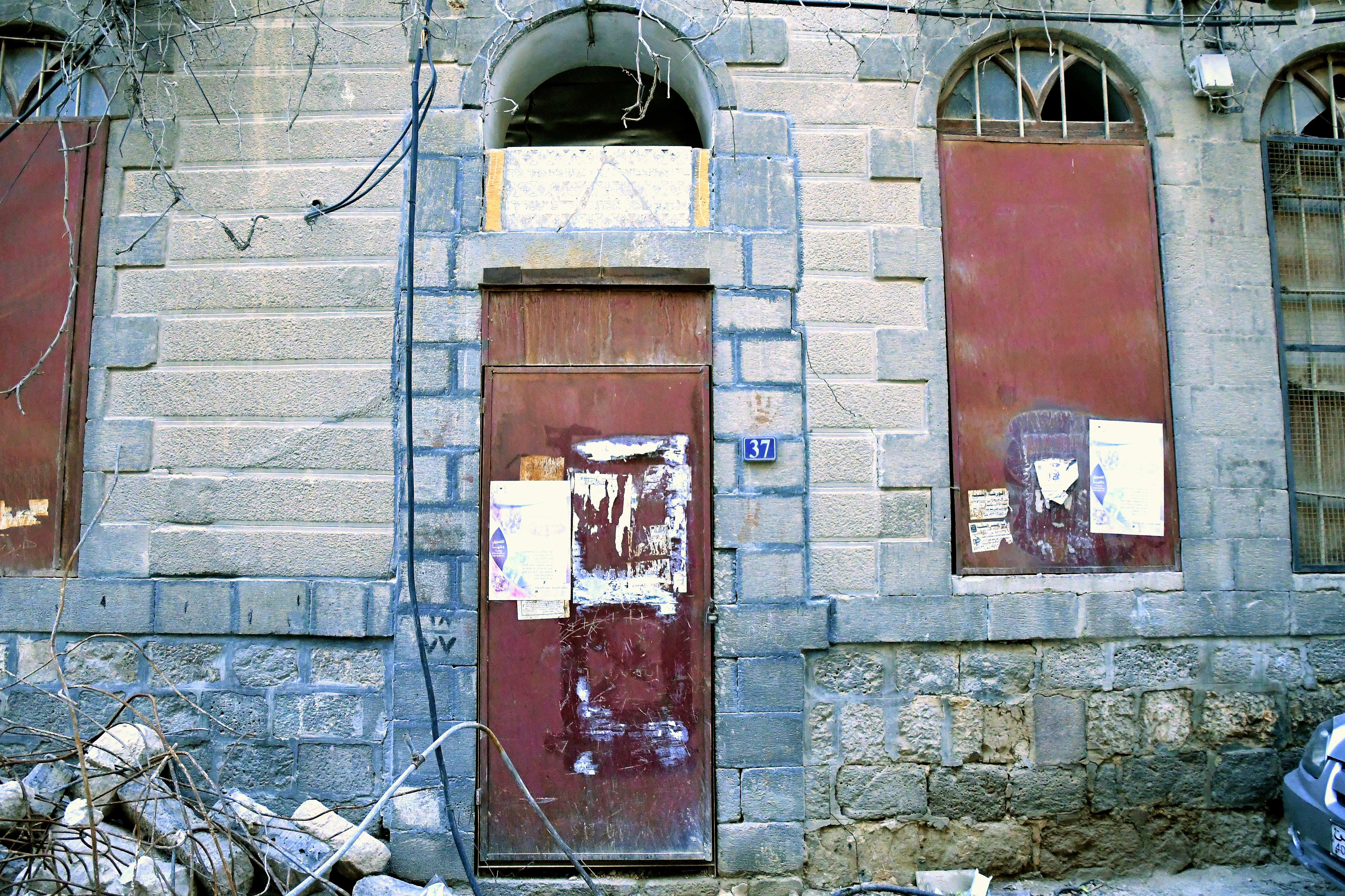 Verlassenes Haus, über der Tür eine Marmortafel mit einem hebräischen Segen aus der Thora (Deut 28:6) für das Haus und alle, die durch die Tür ein- und ausgehen.